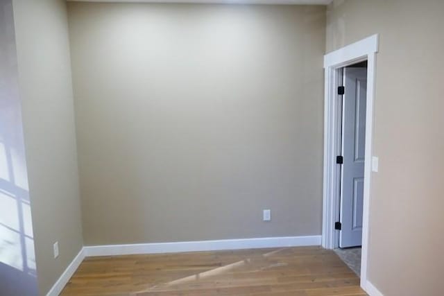 spare room featuring light wood-type flooring and baseboards