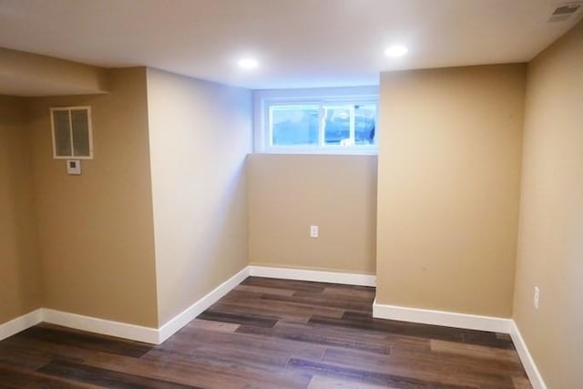 below grade area with visible vents, baseboards, and wood finished floors