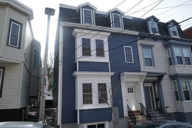 view of front of home featuring entry steps and mansard roof