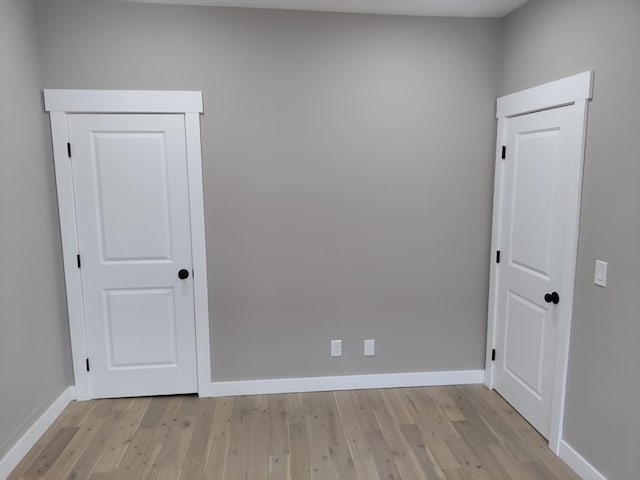 spare room with light wood-type flooring and baseboards