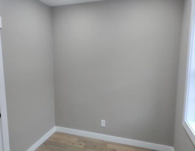 spare room featuring light wood-style flooring and baseboards