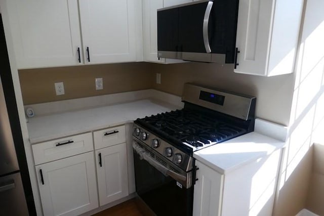 kitchen featuring light countertops, appliances with stainless steel finishes, and white cabinets