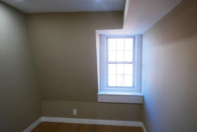 empty room featuring baseboards and wood finished floors