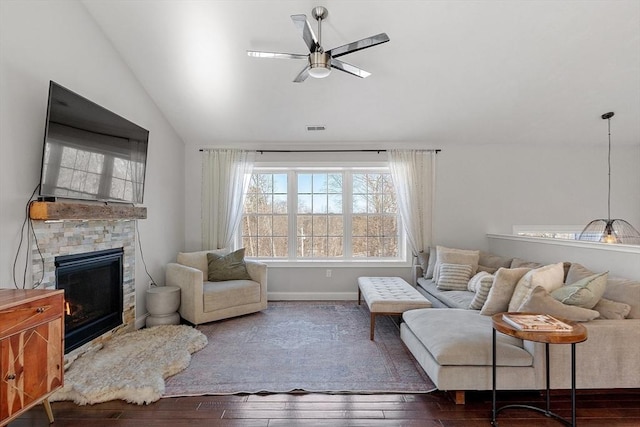 living room with lofted ceiling, visible vents, a ceiling fan, a stone fireplace, and hardwood / wood-style floors