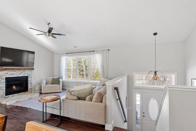 living room with lofted ceiling, a fireplace, a ceiling fan, baseboards, and dark wood finished floors