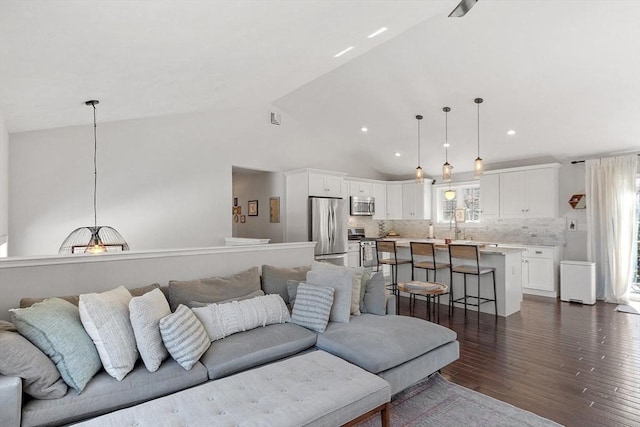 living room featuring high vaulted ceiling, recessed lighting, dark wood-style flooring, and visible vents