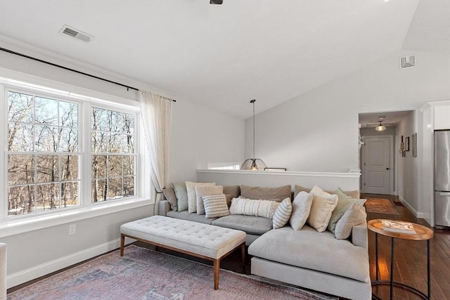 living room with visible vents, vaulted ceiling, baseboards, and wood finished floors