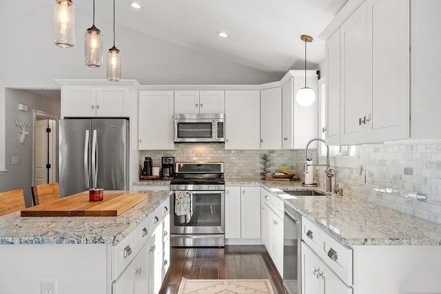 kitchen with lofted ceiling, appliances with stainless steel finishes, white cabinets, and a sink