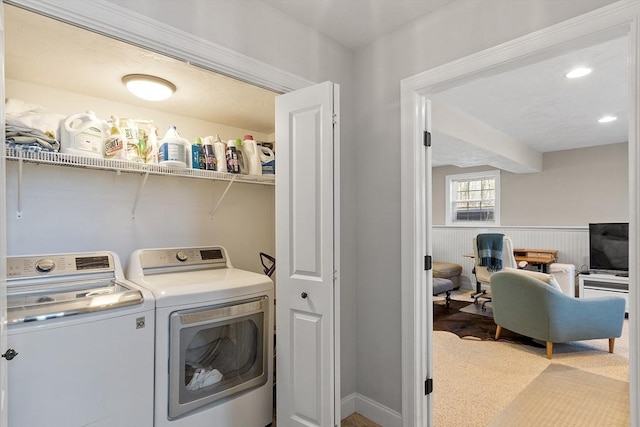 laundry area with carpet floors, laundry area, washer and dryer, and a wainscoted wall