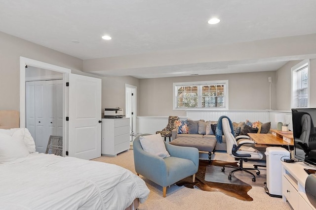 bedroom featuring recessed lighting, a wainscoted wall, and light colored carpet