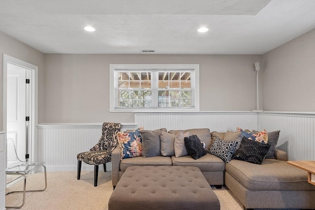 carpeted living area with recessed lighting, visible vents, and wainscoting