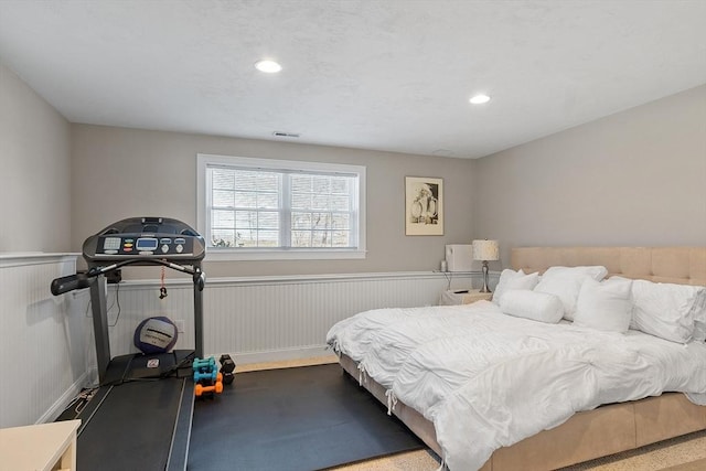 bedroom featuring recessed lighting, visible vents, and wainscoting