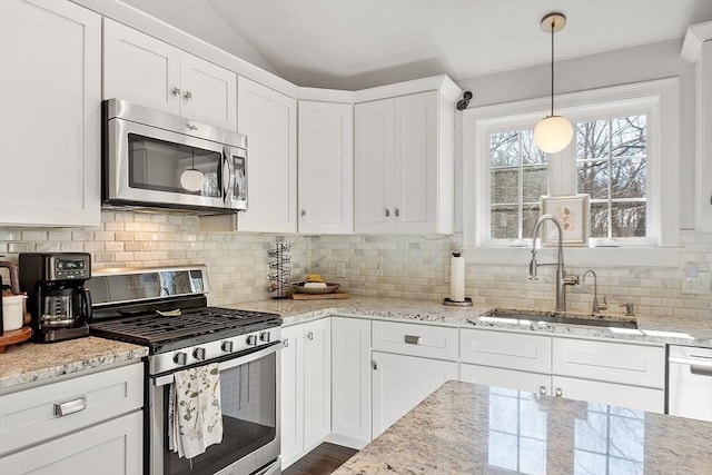 kitchen featuring appliances with stainless steel finishes, a sink, and white cabinetry