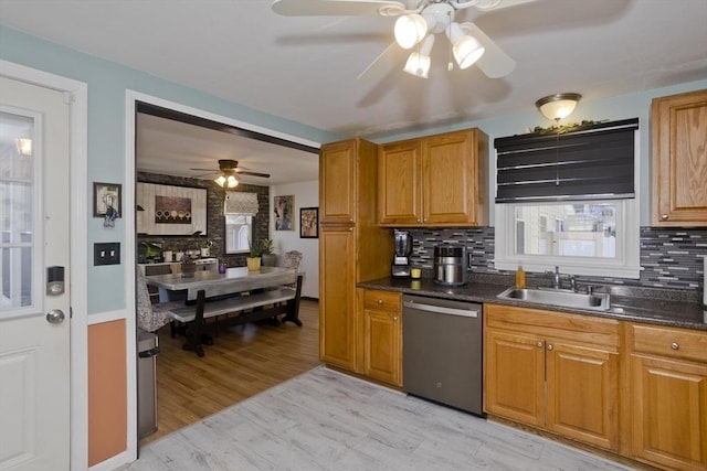 kitchen featuring stainless steel dishwasher, brown cabinetry, a sink, and backsplash