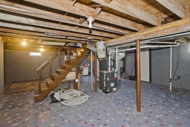 below grade area featuring stairway and heating unit