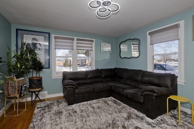 living area featuring visible vents, baseboards, and wood finished floors