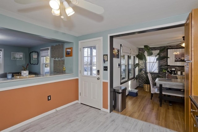 foyer with light wood-style floors, baseboards, and a ceiling fan