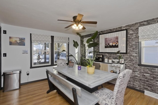 dining area featuring ceiling fan, light wood finished floors, visible vents, and baseboards