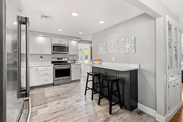 kitchen with light countertops, recessed lighting, appliances with stainless steel finishes, and visible vents
