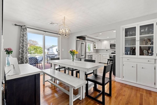 dining area featuring visible vents, recessed lighting, light wood-style flooring, and a notable chandelier