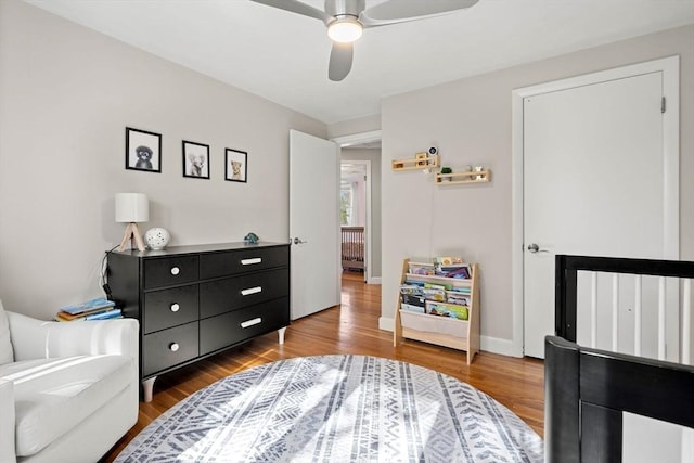 bedroom with radiator, a ceiling fan, and wood finished floors
