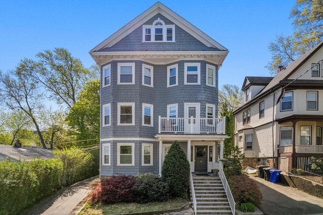 view of front of home with stairs and a balcony