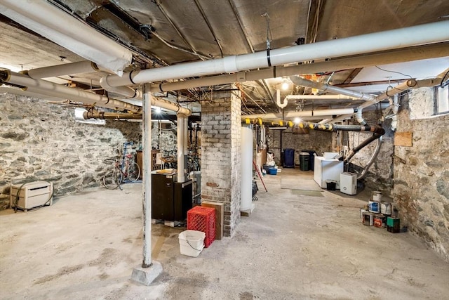 below grade area with water heater, a heating unit, and washer / clothes dryer