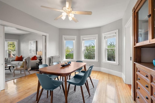 dining area featuring light wood-style flooring, baseboards, and ceiling fan