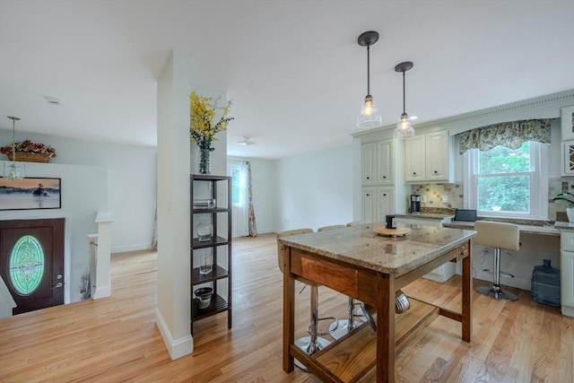 61 Wright Rd, Ayer, MA 01432 - kitchen with tasteful backsplash, light wood-type flooring, decorative light fixtures, and white cabinetry