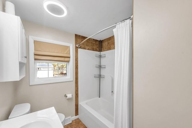 bathroom featuring toilet and shower / bath combination with curtain