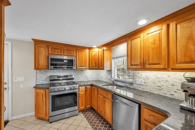 kitchen with light tile patterned floors, stainless steel appliances, backsplash, and sink