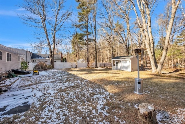 snowy yard featuring a storage shed