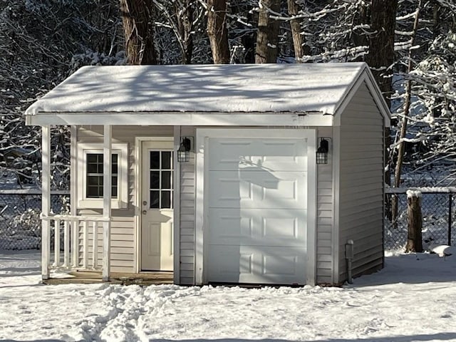 snow covered structure featuring a garage