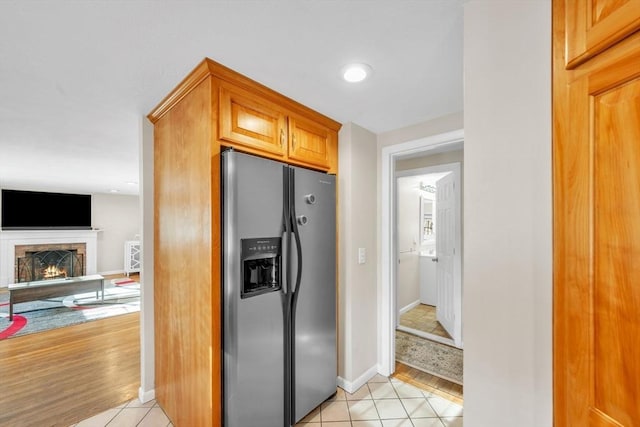 kitchen with light tile patterned floors and stainless steel fridge