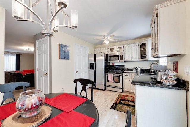1051 Elm St Unit 8, West Springfield, MA 01089 - kitchen with appliances with stainless steel finishes, dark countertops, ceiling fan, light wood finished floors, and glass insert cabinets