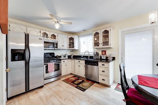 1051 Elm St Unit 8, West Springfield, MA 01089 - kitchen featuring appliances with stainless steel finishes, dark countertops, light wood-type flooring, a ceiling fan, and glass insert cabinets