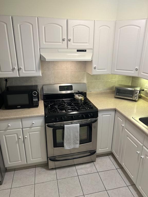 20 Colonial Dr Unit 3, Andover, MA 01810 - kitchen with stainless steel range with gas cooktop, black microwave, under cabinet range hood, and white cabinets