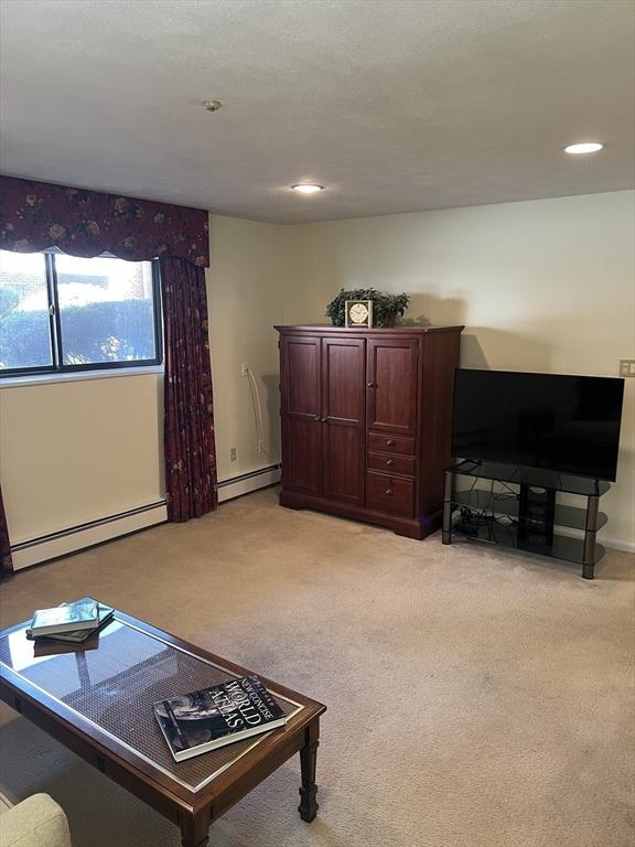 20 Colonial Dr Unit 3, Andover, MA 01810 - living area with a baseboard radiator, light carpet, baseboards, and recessed lighting