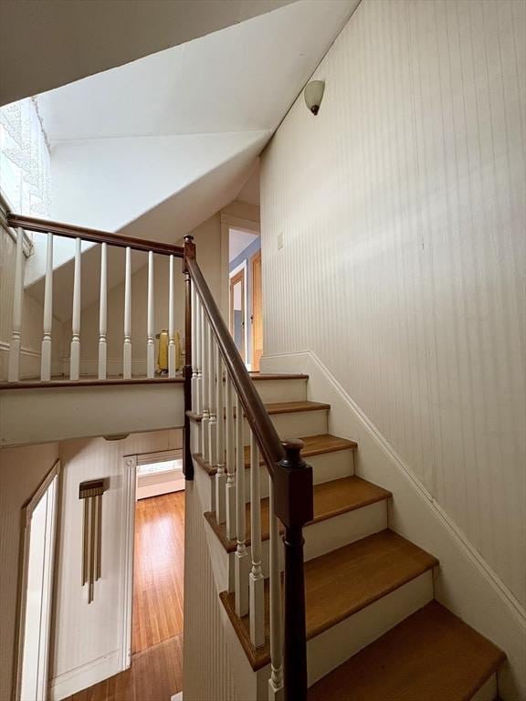 stairs with lofted ceiling and wood finished floors