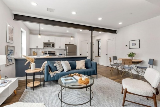 living room featuring beam ceiling and dark hardwood / wood-style flooring