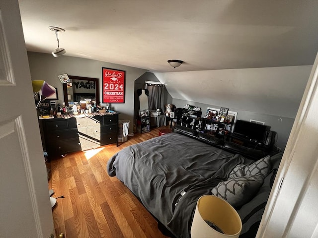 bedroom featuring lofted ceiling and light hardwood / wood-style floors