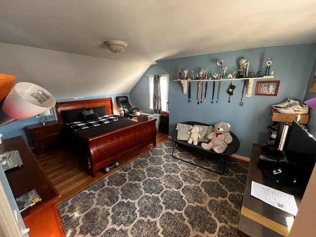 bedroom with vaulted ceiling and dark hardwood / wood-style flooring