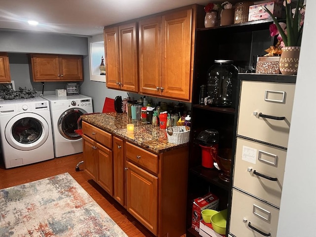 clothes washing area featuring wood-type flooring and washing machine and dryer