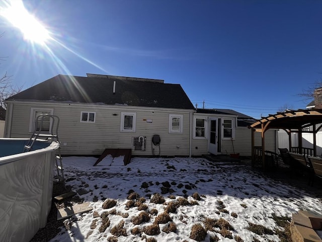 snow covered rear of property featuring a pergola