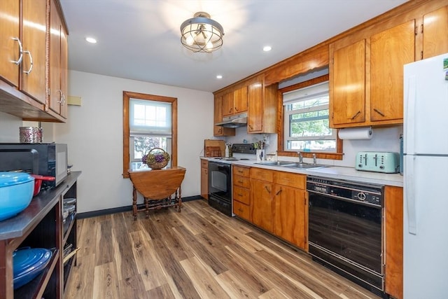 21 Alfred St, Woburn, MA 01801 - kitchen featuring black appliances, a sink, under cabinet range hood, wood finished floors, and light countertops