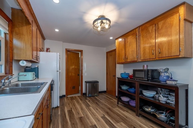 21 Alfred St, Woburn, MA 01801 - kitchen featuring a sink, black microwave, brown cabinetry, wood finished floors, and light countertops