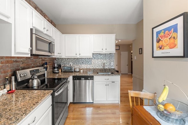 1404 Commonwealth Ave Unit 4-8, Boston, MA 02135 - kitchen featuring stainless steel appliances, light wood-style floors, white cabinetry, tasteful backsplash, and light stone counters