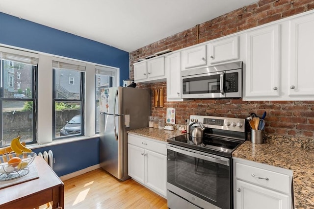 1404 Commonwealth Ave Unit 4-8, Boston, MA 02135 - kitchen featuring stainless steel appliances, backsplash, light wood-style flooring, white cabinets, and light stone counters