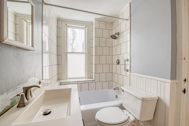 full bath with  shower combination, wainscoting, a sink, and toilet