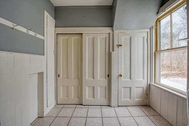 interior space featuring light tile patterned floors and wooden walls